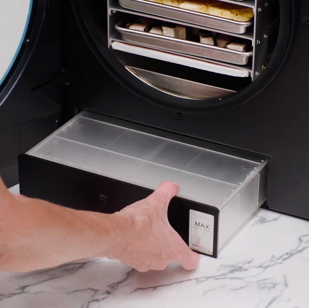 Pulling out the built-in drain pan from under the chamber of the Countertop 360