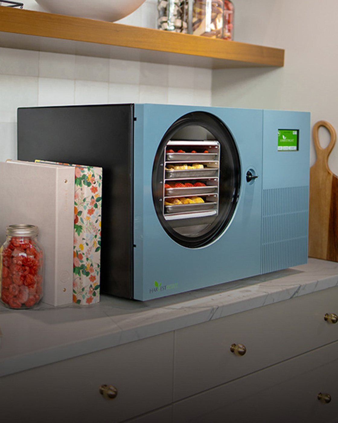 Pale blue Countertop 360 freeze dryer with jars of freeze-dried food